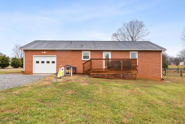 back of house with a yard, a deck, and a garage