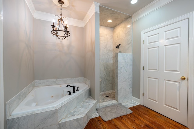 bathroom featuring hardwood / wood-style floors, a notable chandelier, ornamental molding, and separate shower and tub