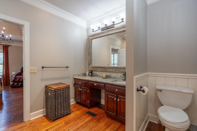 bathroom with vanity, crown molding, toilet, and hardwood / wood-style flooring