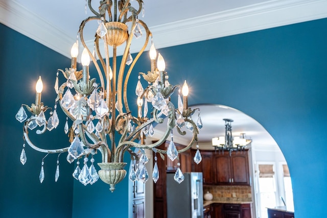 interior details with tasteful backsplash, a notable chandelier, ornamental molding, and high quality fridge