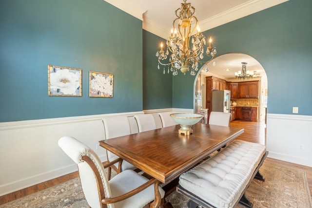 dining room featuring an inviting chandelier, ornamental molding, and light hardwood / wood-style flooring