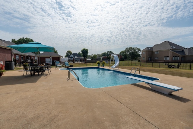 view of pool featuring a diving board, central AC, a patio, and a water slide