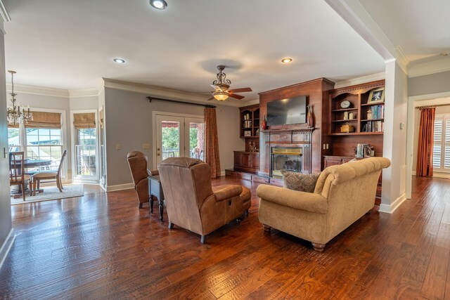 living room featuring ornamental molding, dark hardwood / wood-style flooring, and ceiling fan with notable chandelier