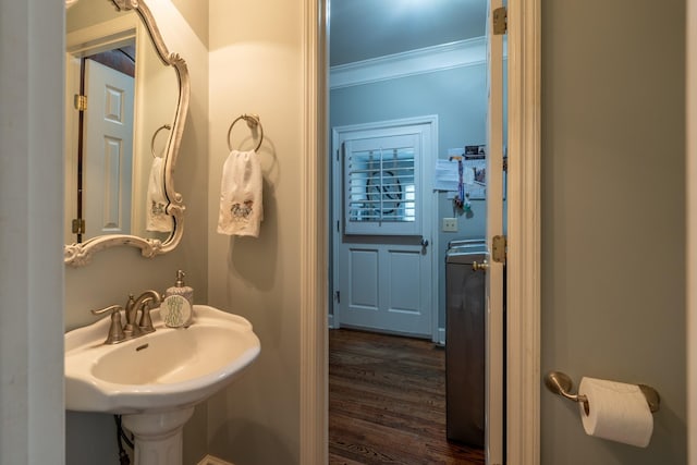 bathroom with crown molding, sink, and hardwood / wood-style flooring