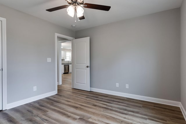 unfurnished bedroom featuring a ceiling fan, baseboards, and wood finished floors