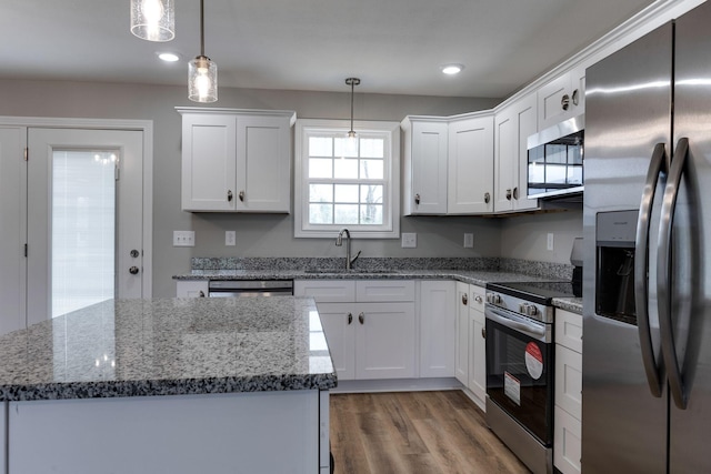 kitchen featuring appliances with stainless steel finishes, light wood-type flooring, a sink, and white cabinetry