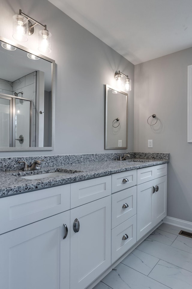 bathroom with a sink, visible vents, marble finish floor, a shower stall, and double vanity