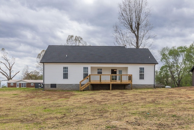 rear view of house featuring a lawn and a deck