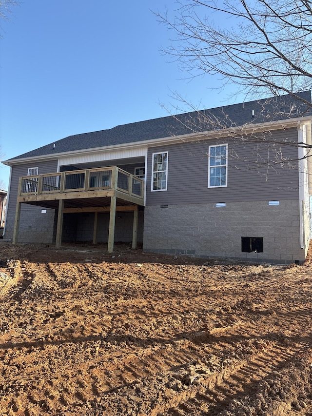 back of property with a deck and crawl space