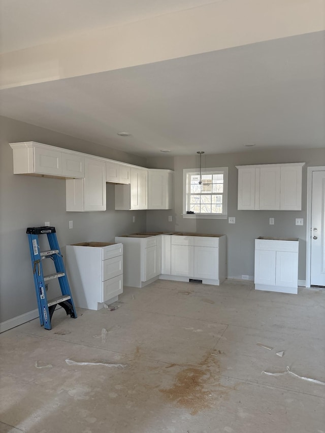 kitchen with white cabinetry and baseboards