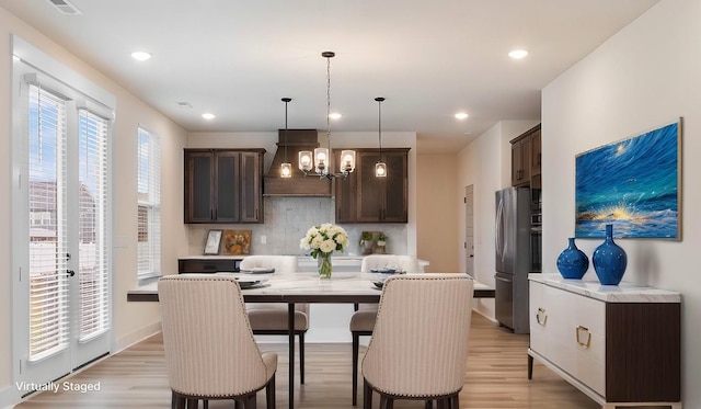 dining area featuring a notable chandelier and light wood-type flooring