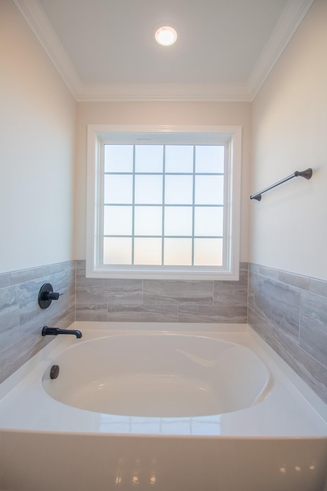 bathroom featuring ornamental molding and a tub