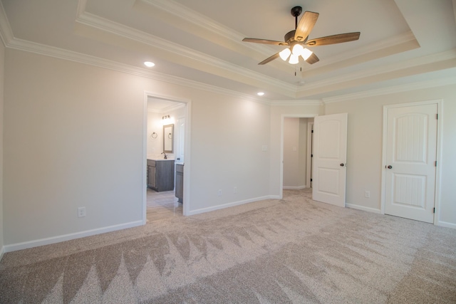 unfurnished bedroom with ornamental molding, a raised ceiling, and light carpet