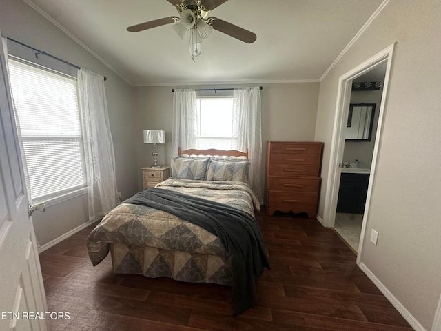 bedroom with crown molding, ceiling fan, connected bathroom, and dark wood-type flooring