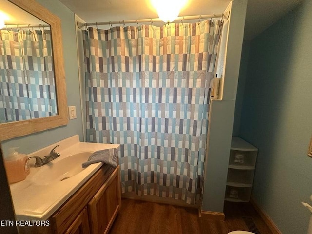 bathroom featuring walk in shower, vanity, and hardwood / wood-style flooring