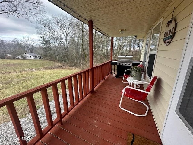 wooden deck with a grill and a yard