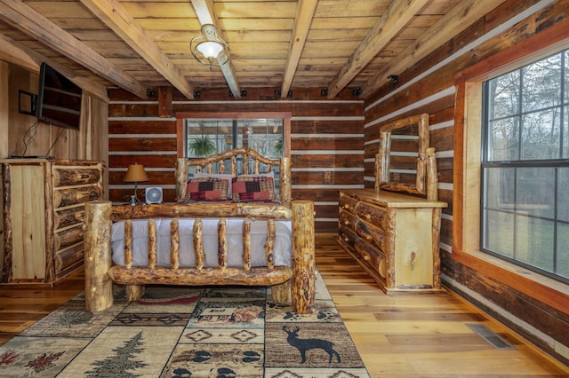 unfurnished bedroom featuring beam ceiling, wood ceiling, light hardwood / wood-style floors, and wood walls