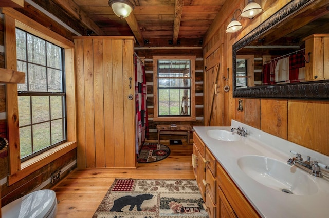 bathroom featuring hardwood / wood-style floors, wood ceiling, wooden walls, and a wealth of natural light