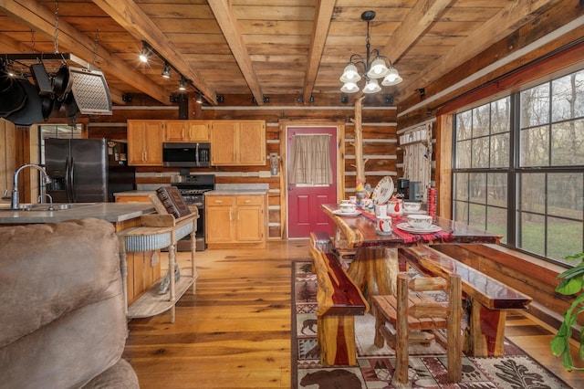 dining area with sink, a wealth of natural light, and wooden ceiling