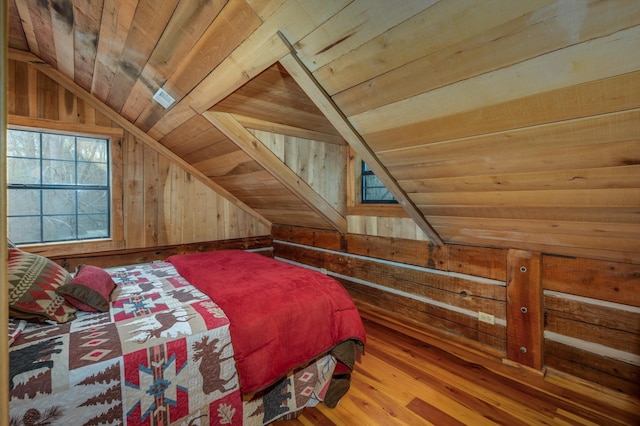 bedroom featuring lofted ceiling, wood-type flooring, wooden walls, and wooden ceiling