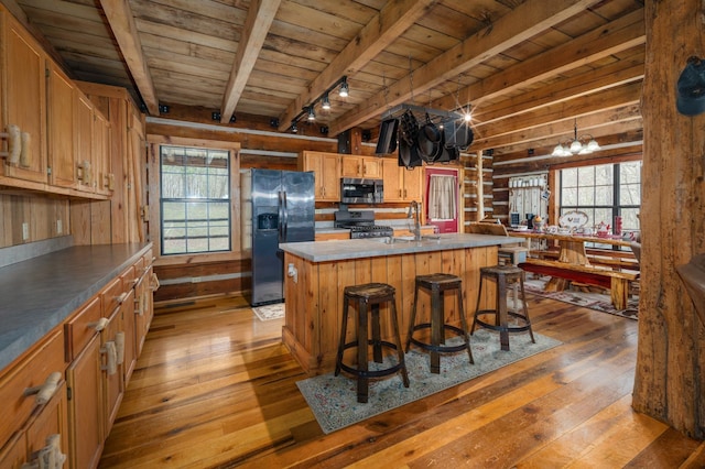 kitchen featuring a kitchen island, a kitchen bar, wood ceiling, stainless steel appliances, and light wood-type flooring