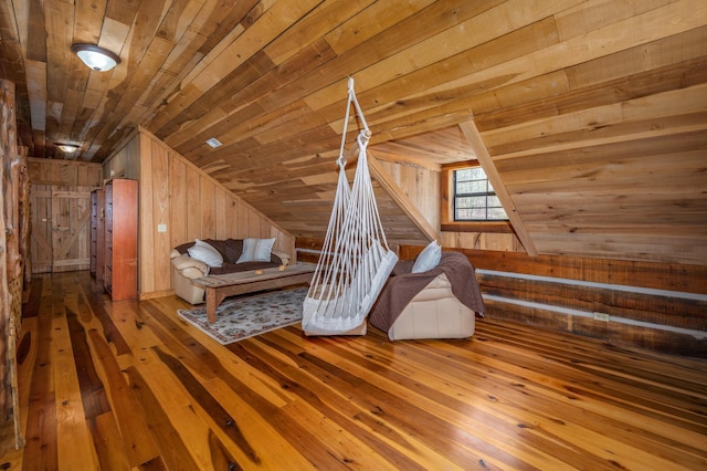 unfurnished room with hardwood / wood-style flooring, lofted ceiling, wood ceiling, and wood walls