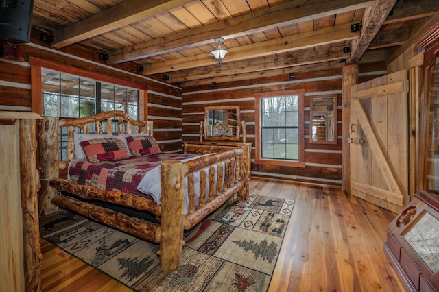 bedroom featuring light hardwood / wood-style flooring, wooden walls, beam ceiling, and wooden ceiling