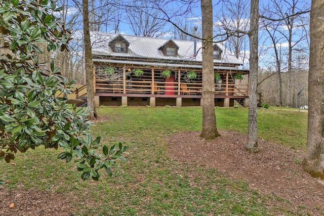 rear view of property with a wooden deck and a yard