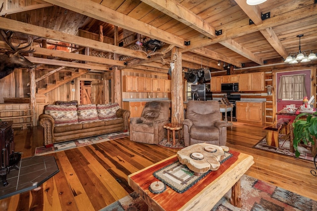 living room featuring beamed ceiling, wood ceiling, a chandelier, and light hardwood / wood-style flooring