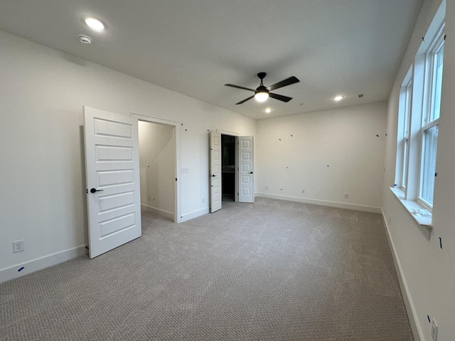 unfurnished bedroom featuring light colored carpet and ceiling fan