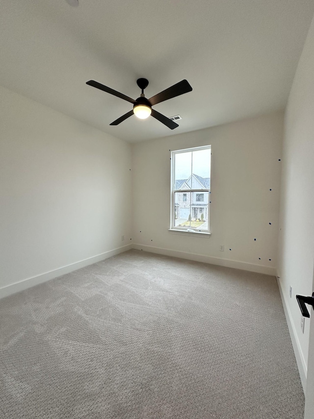 empty room featuring light colored carpet and ceiling fan