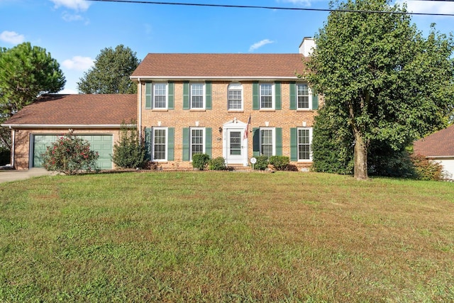 colonial house featuring a garage and a front yard