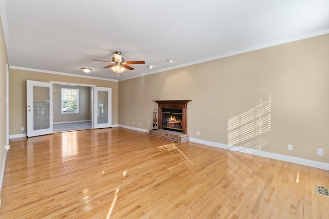 unfurnished living room featuring crown molding, a fireplace, and light hardwood / wood-style flooring