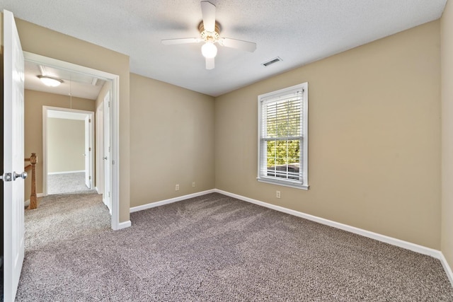 unfurnished room with ceiling fan, carpet, and a textured ceiling