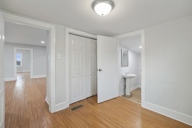 unfurnished bedroom featuring sink, hardwood / wood-style flooring, and a closet