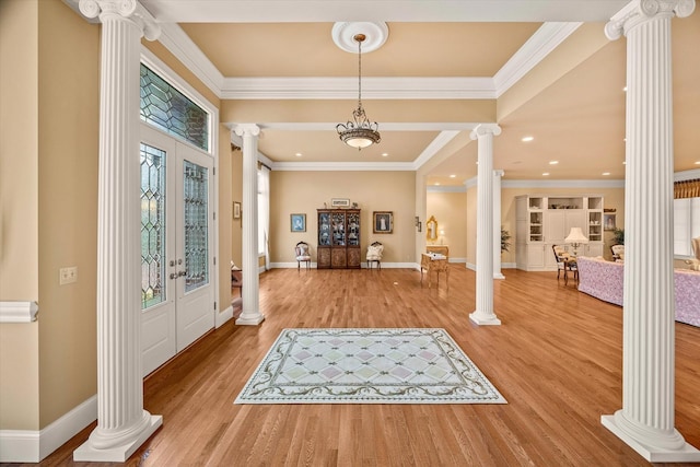 entrance foyer with crown molding, hardwood / wood-style flooring, decorative columns, and french doors