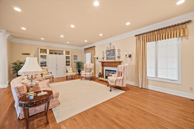 living room with ornamental molding and light hardwood / wood-style flooring