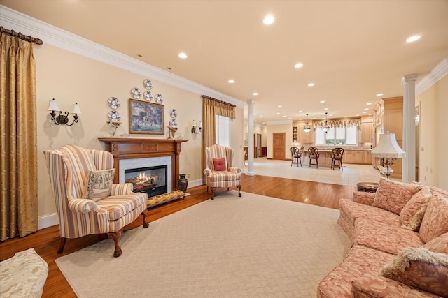 living room with crown molding, a high end fireplace, and light hardwood / wood-style floors