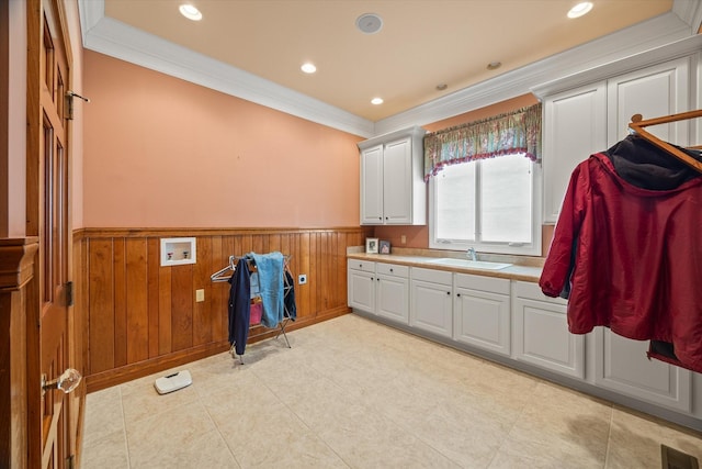 laundry area with wooden walls, sink, cabinets, washer hookup, and crown molding