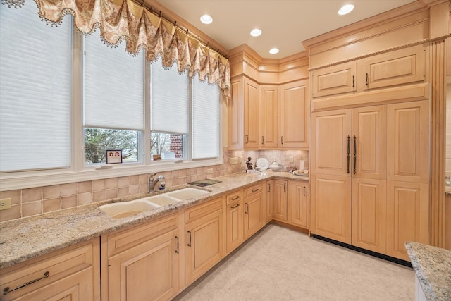 kitchen featuring tasteful backsplash, light stone countertops, sink, and light brown cabinetry