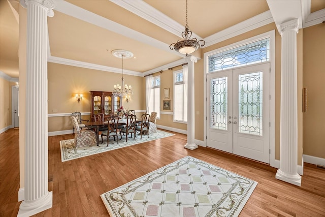 entrance foyer featuring an inviting chandelier, hardwood / wood-style flooring, ornamental molding, and decorative columns