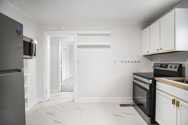 kitchen with ornamental molding, appliances with stainless steel finishes, and white cabinets