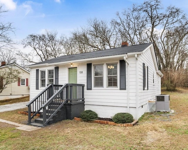 view of front of property featuring central AC unit and a front lawn