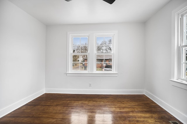 empty room with a wealth of natural light, ceiling fan, baseboards, and wood finished floors