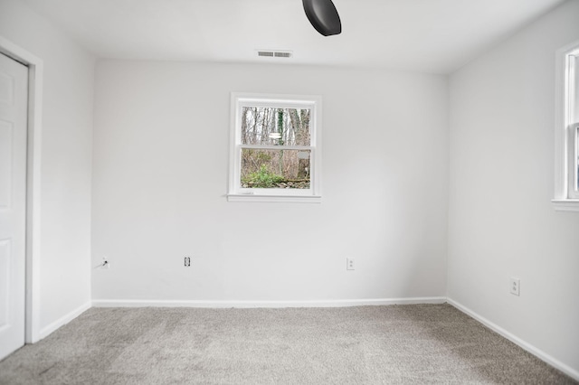 carpeted empty room with visible vents and baseboards