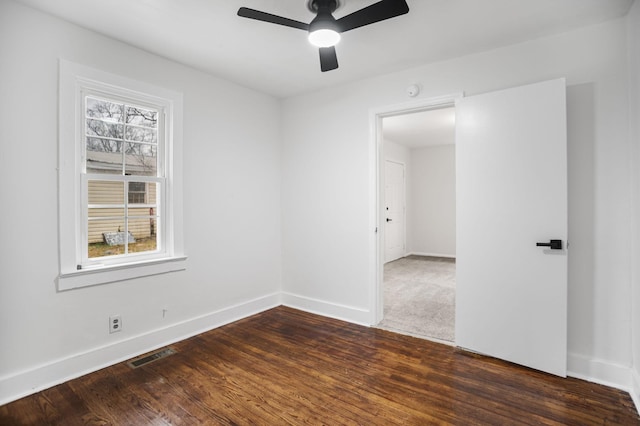 empty room featuring visible vents, baseboards, ceiling fan, and wood finished floors