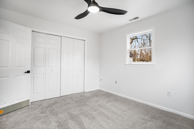 unfurnished bedroom featuring ceiling fan, light colored carpet, and a closet