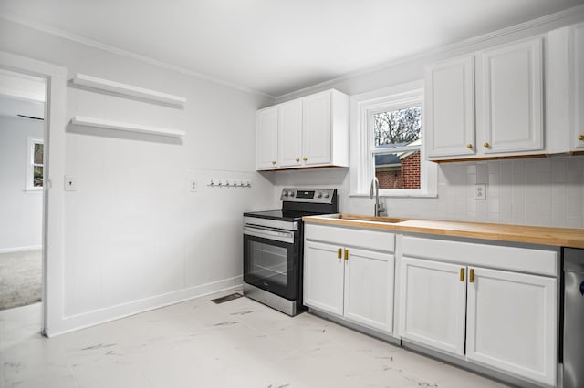 kitchen with butcher block countertops, a sink, stainless steel range with electric cooktop, white cabinetry, and backsplash