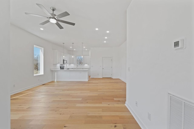 unfurnished living room with ceiling fan and light hardwood / wood-style flooring