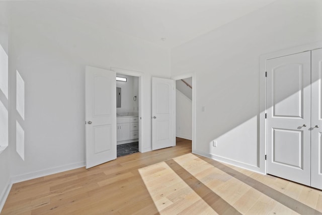 bedroom featuring ensuite bathroom and light hardwood / wood-style flooring